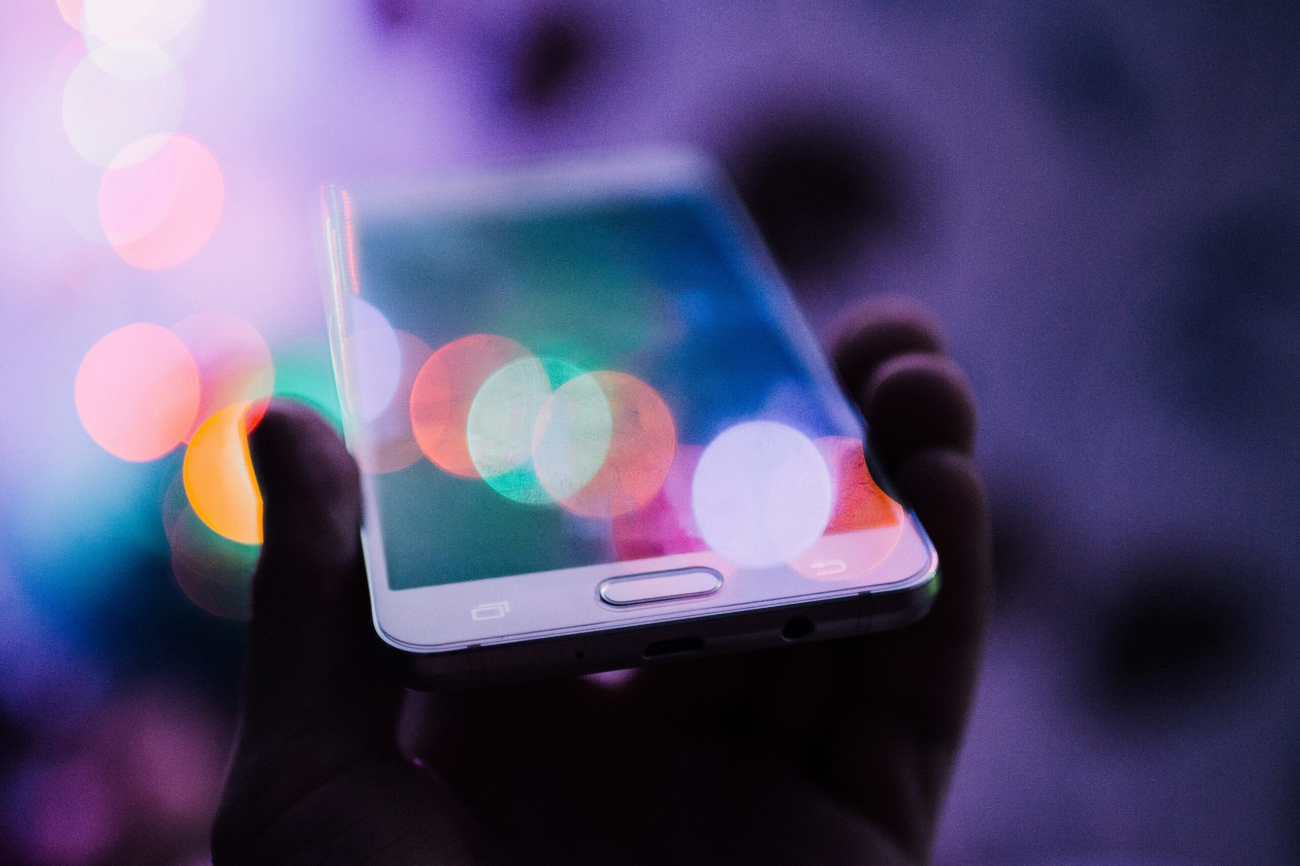 mobile phone in hand with neon lights