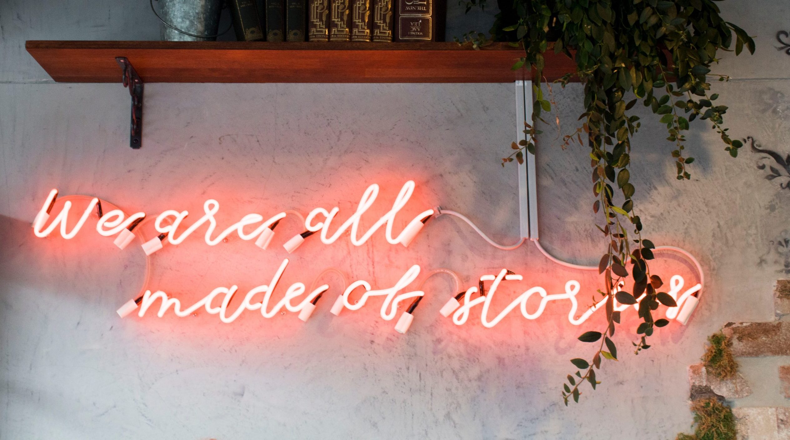 a neon sign describing words that we're all made of stories